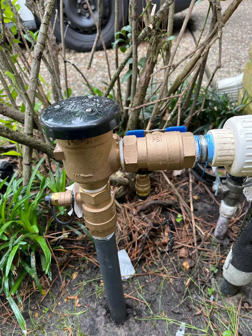 Close-up of a garden water valve with attached hose connectors.