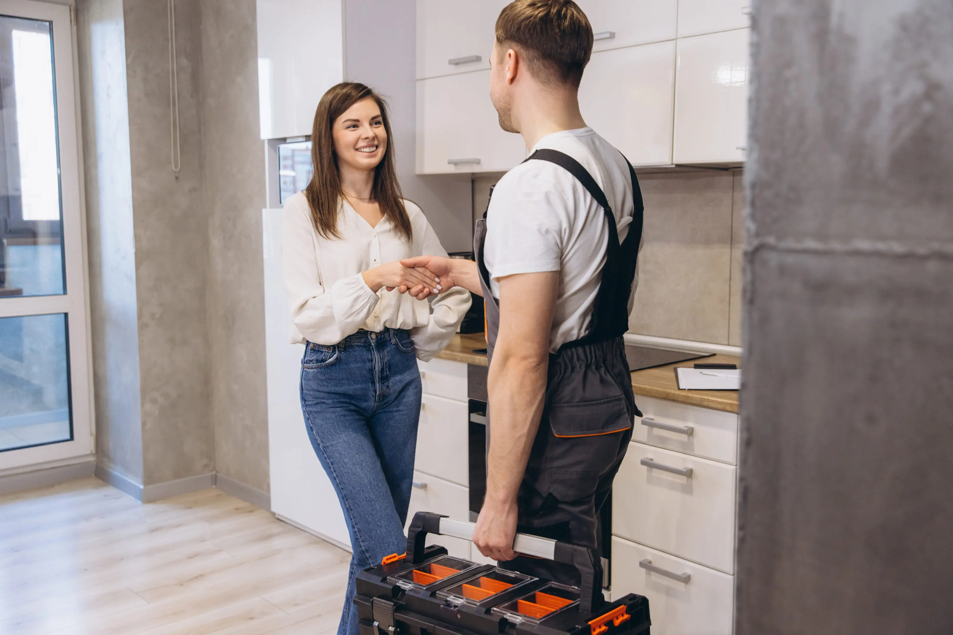 Woman consulting a technician in a modern kitchen.