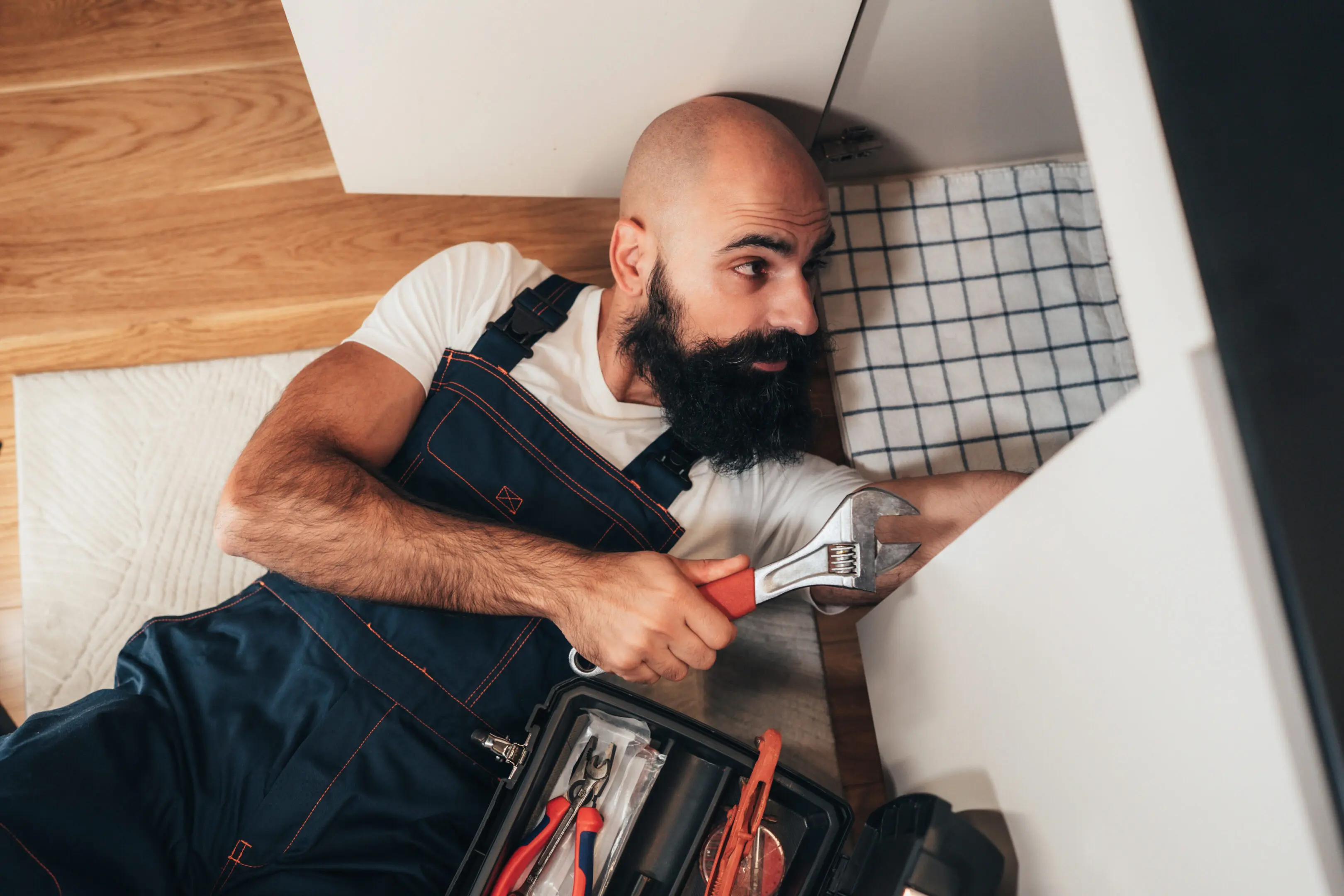 Handyman fixing a tile wall with a drill.