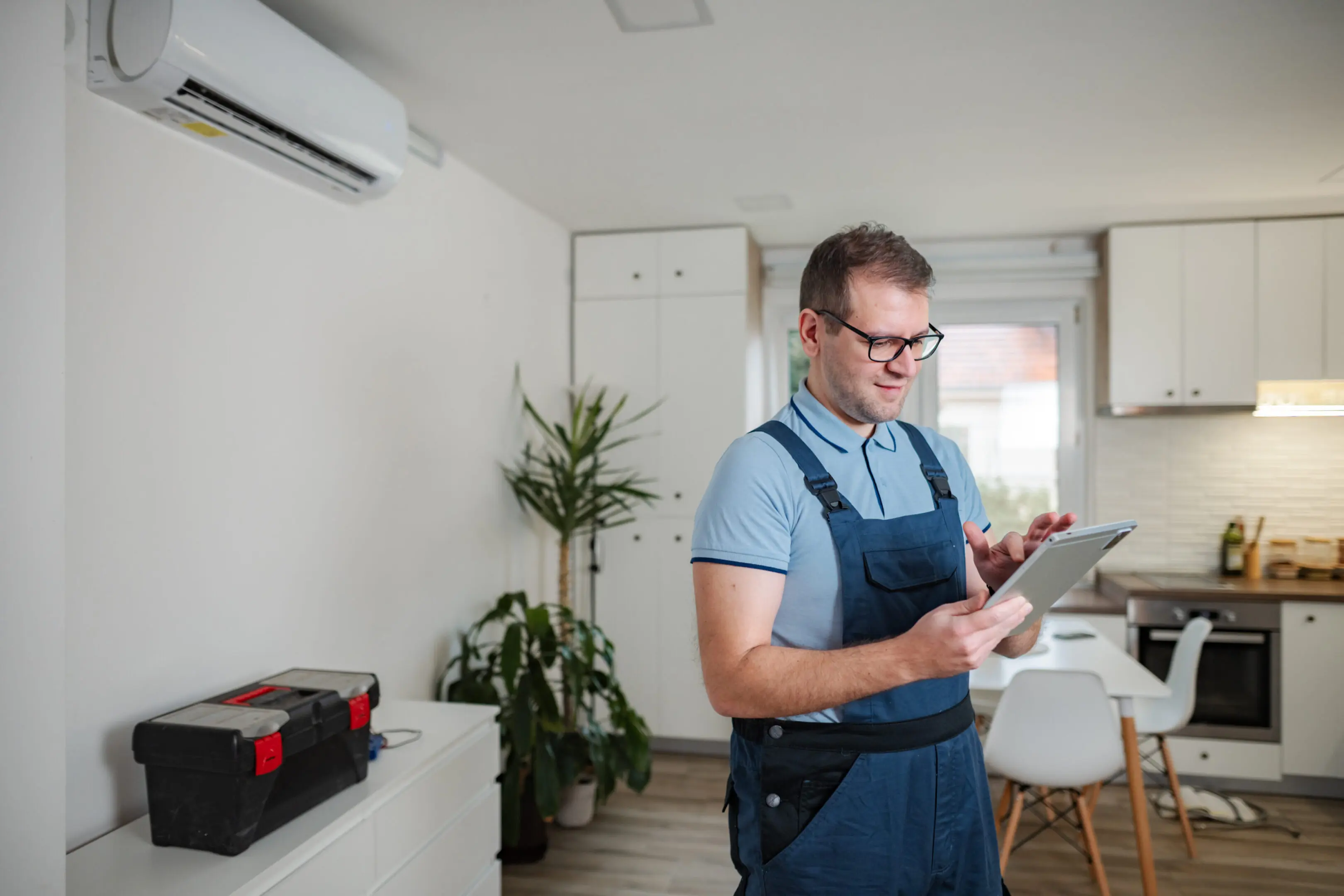 Craftsman inspecting wooden plank in workshop with tools.