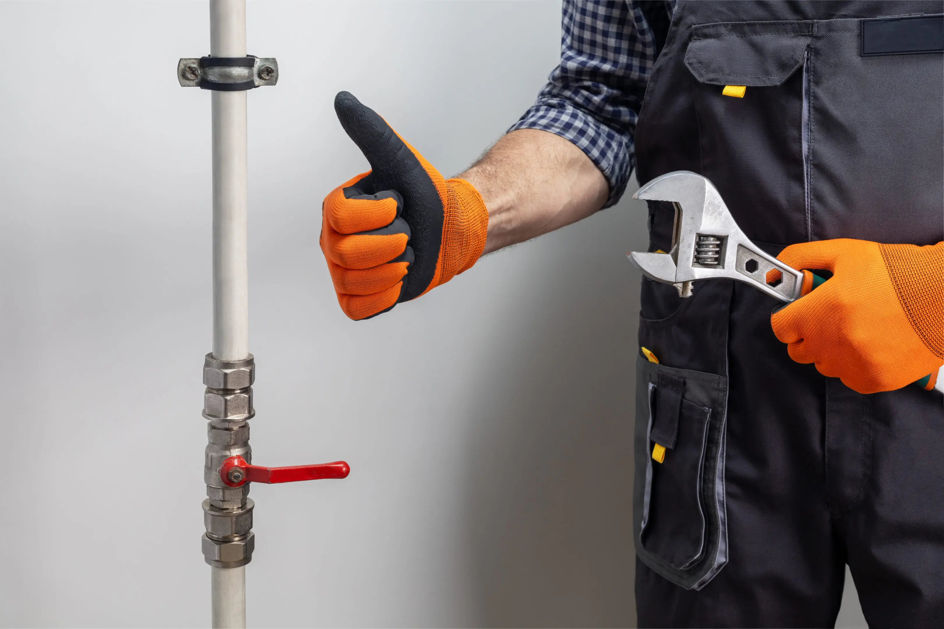 Plumber giving thumbs up while working on pipe fitting.