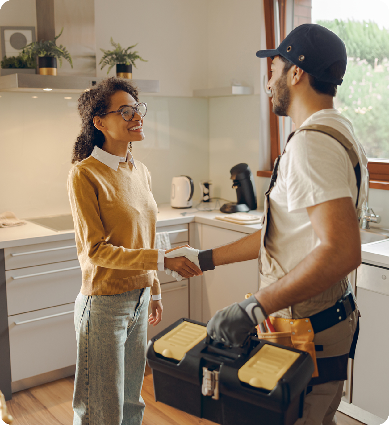 Homeowner greeting handyman with toolbox.