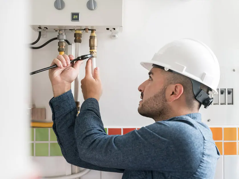 Technician fixing a boiler with tools