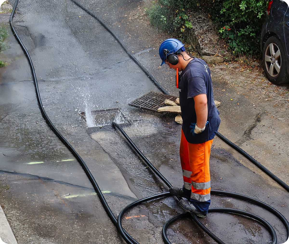 Worker inspecting street with water hoses