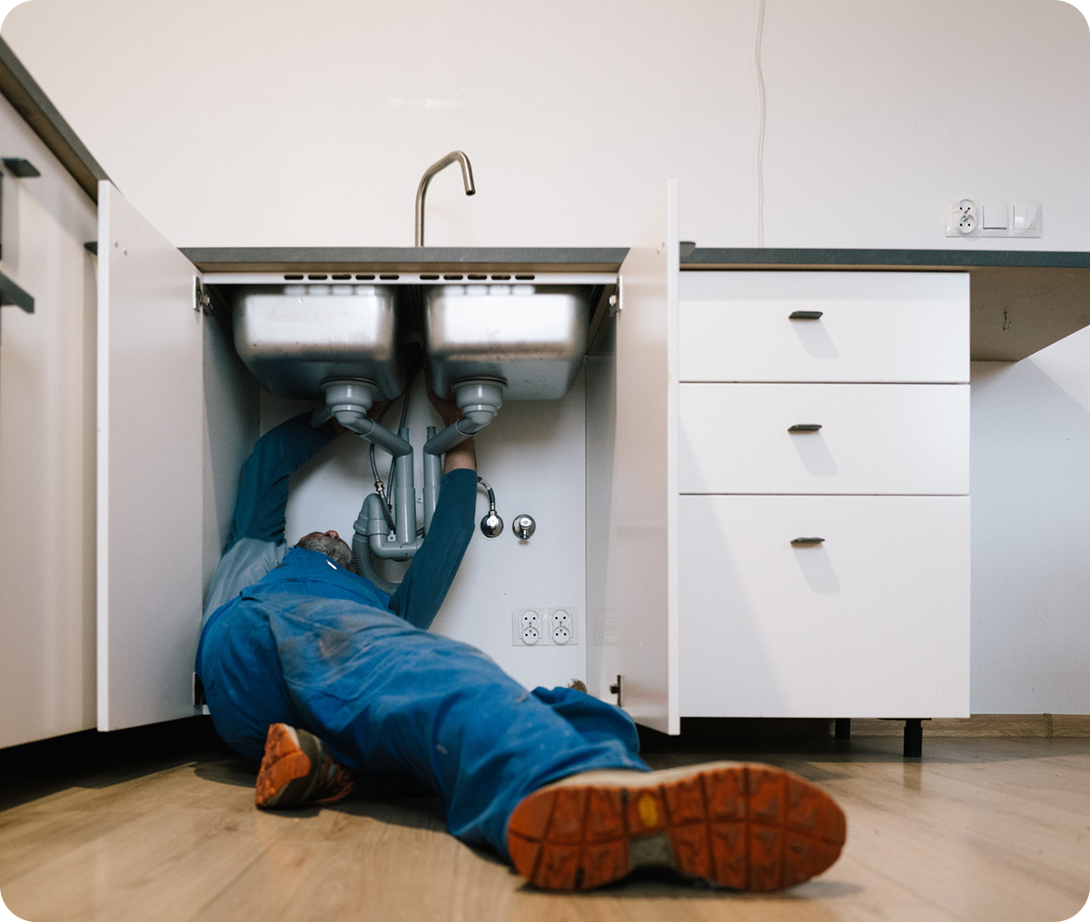 Technician repairing kitchen plumbing system