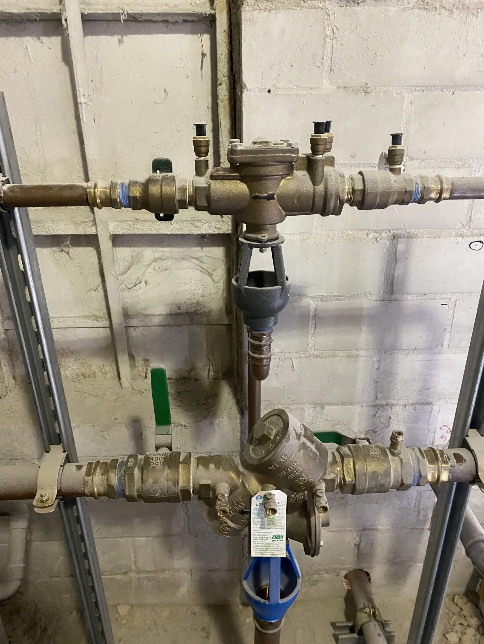 Industrial pipes and valves on concrete wall.