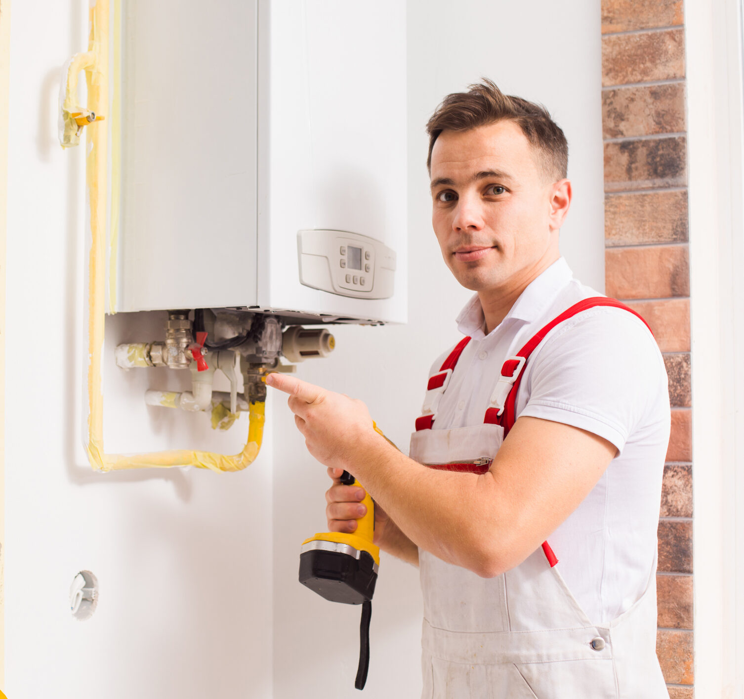 Technician inspecting and repairing a home boiler system.