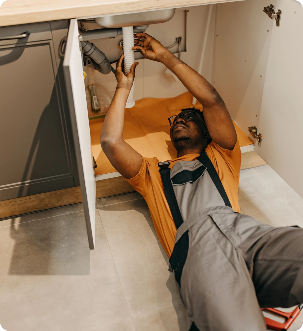 Man working beneath kitchen sink
