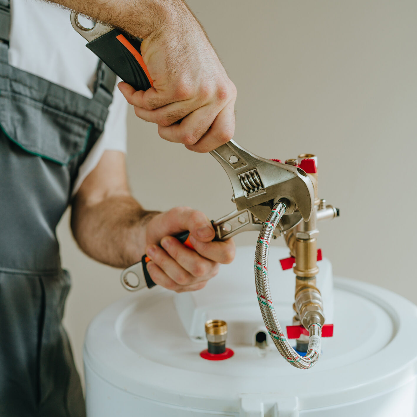 Person assembling or repairing a water heater component.