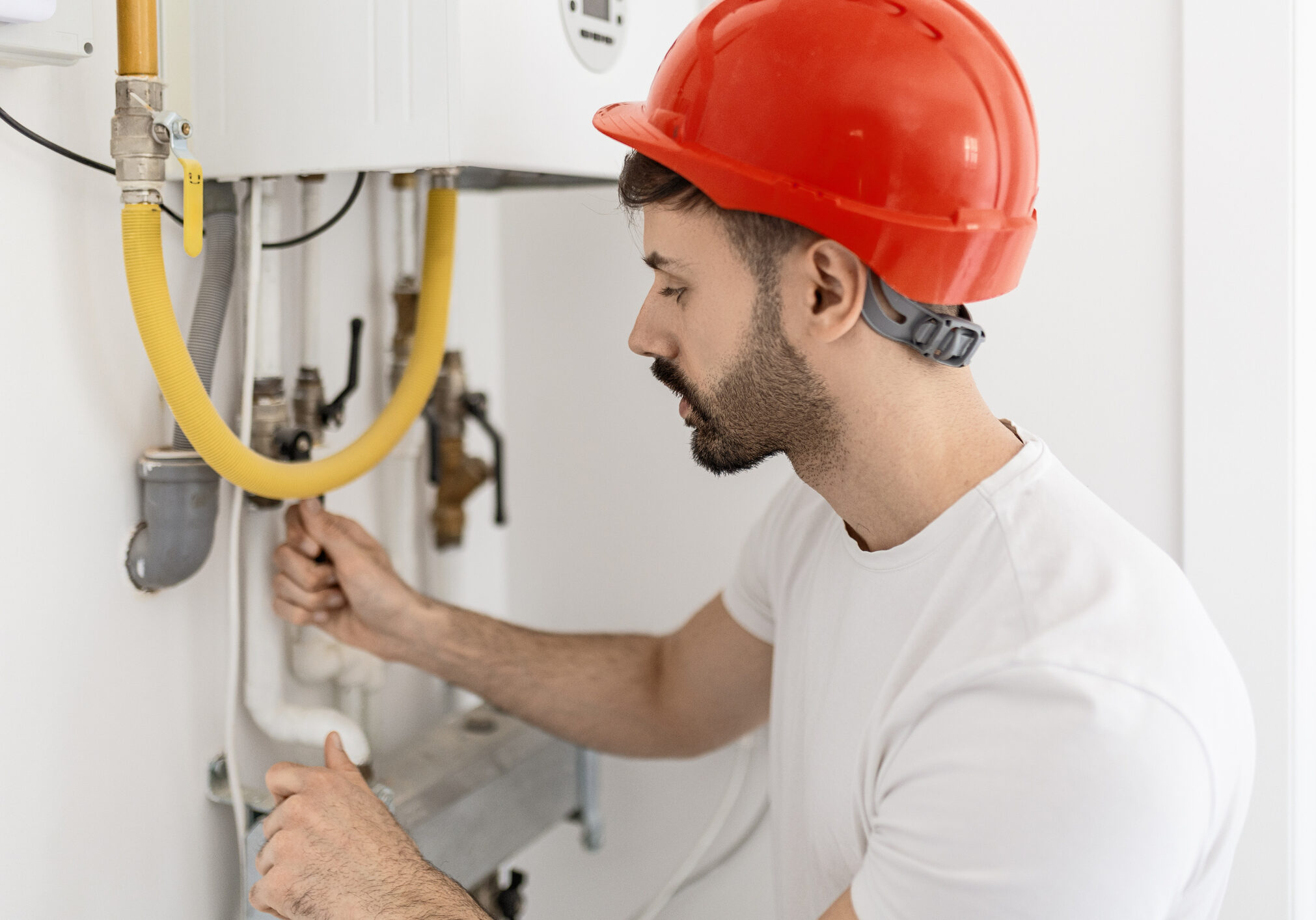 Technician adjusting a component inside a boiler system.