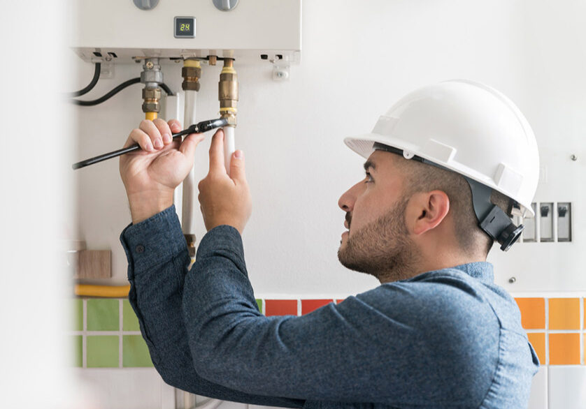 Technician fixing a boiler with tools